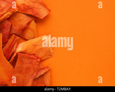 Dried organic papaya slices on an orange studio background, healthy food concept, view from above, space for text Stock Photo