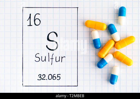 Handwriting chemical element Sulfur S with some pills. Close-up. Stock Photo