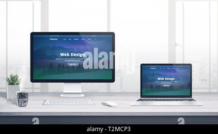Computer display and laptop on web development studio work desk. Concept of modern, responsive web site design. Stock Photo