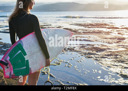 Surfer with surfboard on beach Stock Photo