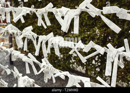 Omikuji fortunes on display at the Fushimi Inari-Taisha shrine in Kyoto, Japan Stock Photo