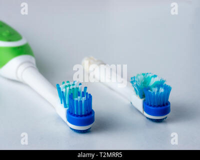 Head electrical toothbrush close up. New and old nozzle electric toothbrushes. Used up electrical toothbrush heads on white background. Copy space Stock Photo