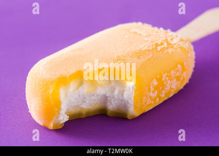 Orange popsicle on violet background Stock Photo