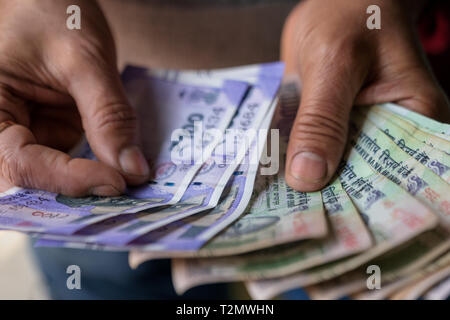 Indian business man counting cash banknotes of newly launched 100 rupees. Money counting concept for background. Stock Photo