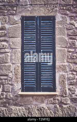 Old wooden closed window shutters of a Mediterranean style house, color toning applied. Stock Photo