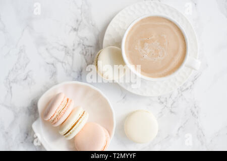 Elegant sweet dessert macarons and cup of coffee on white marble table closeup Stock Photo