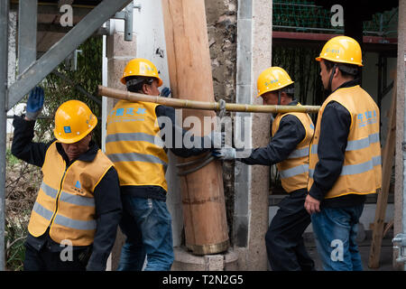 01 April 2019, Hessen, Frankfurt/Main: At a press conference on the reconstruction of the Chinese Pavilion in Bethmannpark, Chinese workers were throwing a trunk of eucalyptus at the construction site. At the beginning of June 2017 the building was destroyed by fire. Photo: Lennart Stock/dpa Stock Photo