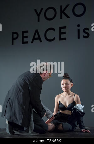 03 April 2019, Saxony, Leipzig: Alfred Weidinger, Director of the Museum der bildenden Künste Leipzig, cuts the robe of the artist Echo Morgan at the opening of the exhibition 'Yoko Ono - Peace is Power'. The performance shows Yoko Ono's 'Cut Piece'. The show 'Yoko Ono - Peace is Power' comprises 70 works and series by the conceptual artist. Ono is the widow of the Beatles singer John Lennon. The exhibition will be open until 07 July. Photo: Hendrik Schmidt/dpa-Zentralbild/dpa Stock Photo