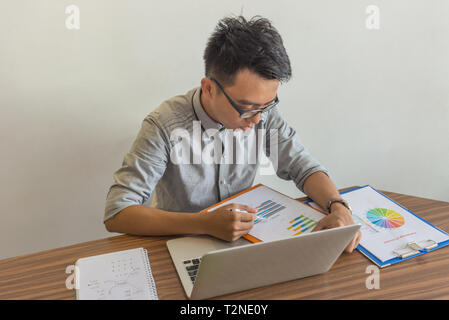 Asian businessman reading financial report document in the office Stock Photo