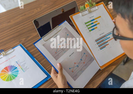 Office employee checking the data on sales reports in office Stock Photo