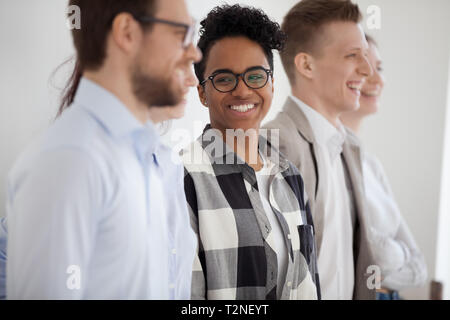 Smiling laughing leader African woman standing with company staff professionals together talking have a fun. Diverse group business people employees i Stock Photo