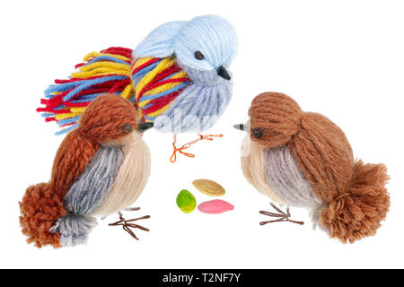 Funny handmade Easter birds are made of thread and peck  pumpkins  seeds. Isolated on white studio macro shot Stock Photo