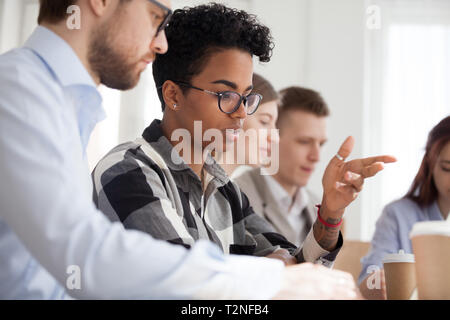 Diverse colleagues sitting at the desk in office boardroom discussing talking about new project, development and plan. Black woman leader with team at Stock Photo