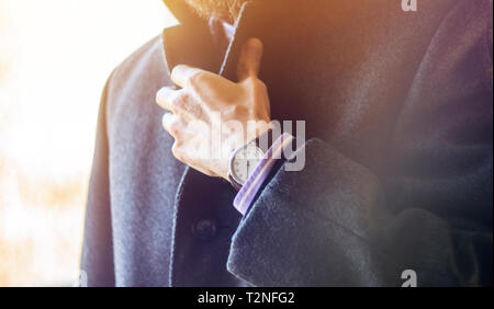 Man Adjusting Collar in Gray Woolen Coat Close-Up. Business Clothes and Accessories Stock Photo