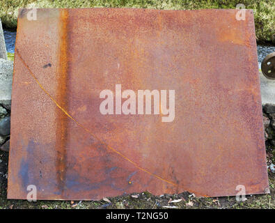 Large rusty iron sheet on a rustic courtyard lie Stock Photo