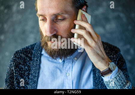Distraught with Grief, a Bearded Man Who Received Bad News by Telephone. Unpleasant Conversation. Getting Bad News Concept Stock Photo