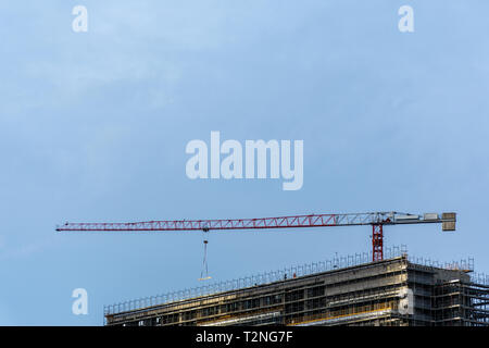 Crane and scaffolding surround a high rise under construction in Milan, Italy Stock Photo
