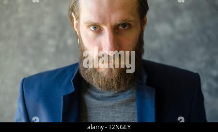 Fashion Portrait of Bearded Man in Blue Suit Blazer with Angry Look at Camera. Stern Look Concept Stock Photo