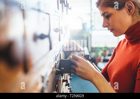 Young librarian opens library card index Stock Photo
