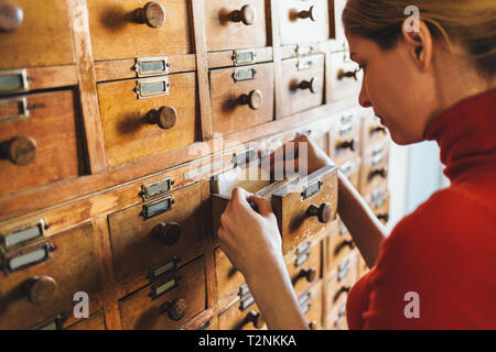 Woman opens database drawer.  Archive, database, library concept Stock Photo