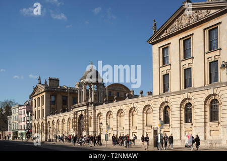 Tourists pass Queen's College Oxford on the High Street Stock Photo