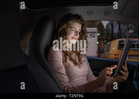 Young woman using digital tablet inside car Stock Photo
