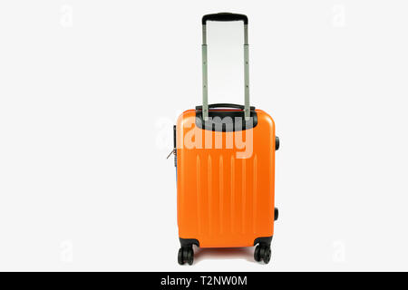 modern orange suitcase with the handle up. Ready to go for your vacation or business trip. The suitcase is on a white background with space next to it Stock Photo