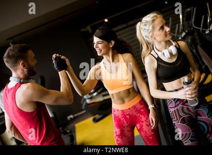 Young woman and personal male trainer rest in the gym after workout Stock Photo