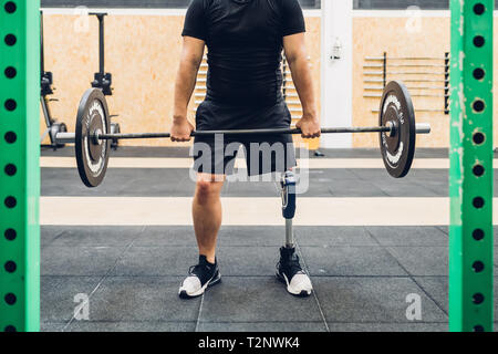 Man with prosthetic leg weight training in gym Stock Photo