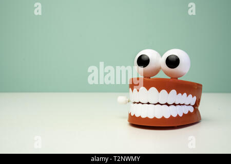 chattering teeth toy on a table with a green background. Jaw funny teeth Stock Photo