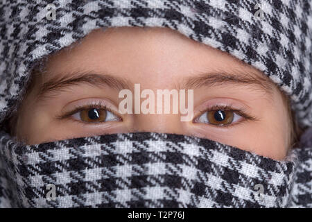 young girl with a veil covering her, close up, studio picture Stock Photo