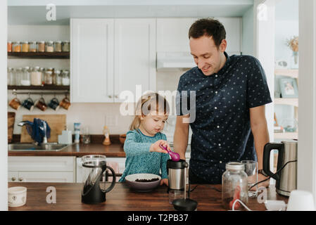 Female toddler and father preparing food at kitchen counter Stock Photo