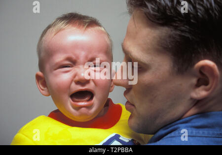 father holding screaming baby boy Stock Photo