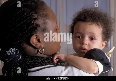 black mother holding her crying toddler Stock Photo