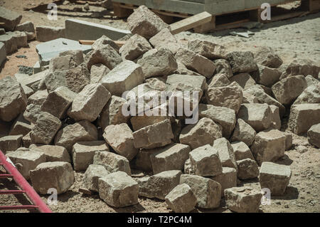 Close-up of setts stones pile in a construction site of street being renovated at Avila. With an imposing wall around the gothic city center in Spain. Stock Photo