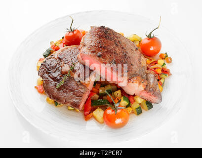 Medium fried steak with vegetables shot on light background, not isolated Stock Photo