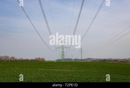 Electric high voltage pylon for power distribution line standing on green field