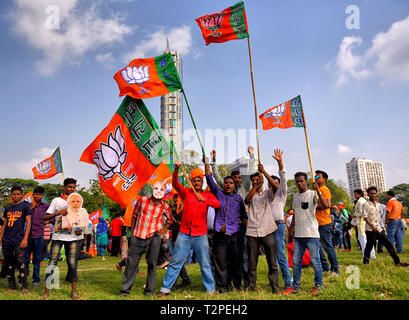 Supporters of BJP seen waving Flags walking towards the meeting place of Brigade Parade Ground. Bharatiya Janata Party (BJP), the main ruling party of India organised a mass rally, as their Leader & Prime Minister of India Mr. Narendra Modi visited Kolkata and addressed the general public ahead of the General Election of India which start 11th April, 2019. Around 150000 people / supporters gathered to listen to the speech from Prime Minister of India at Brigade parade ground. Stock Photo