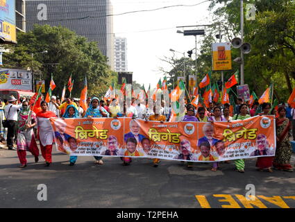 Supporters of BJP seen waving the Flags & walking with banners towards the meeting place of Brigade Parade Ground. Bharatiya Janata Party (BJP), the main ruling party of India organised a mass rally, as their Leader & Prime Minister of India Mr. Narendra Modi visited Kolkata and addressed the general public ahead of the General Election of India which start 11th April, 2019. Around 150000 people / supporters gathered to listen to the speech from Prime Minister of India at Brigade parade ground. Stock Photo