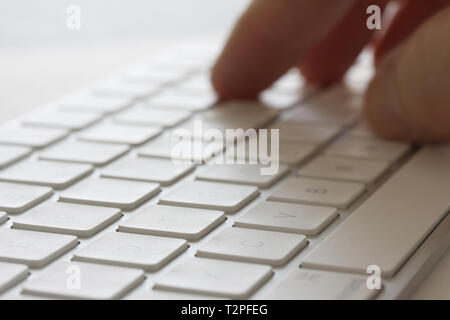 Fingers typing on keybord. Selective focus and extreme close up and hard contrast fading out for copy writing background. Stock Photo