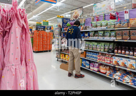 Walmart store interior with male employee stocking a shelf. USA. Stock Photo