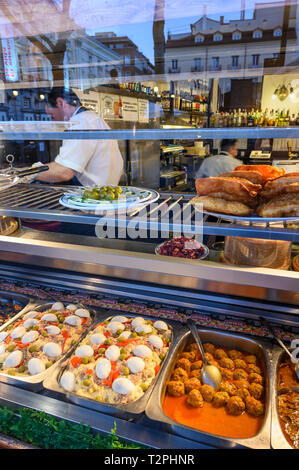 A variety of food dishes seen through the window of a Tapas bar in the Plaza de Santa Ana  central Madrid. Spain Stock Photo