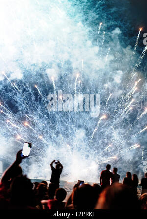 Group of people watching fireworks display at night Stock Photo