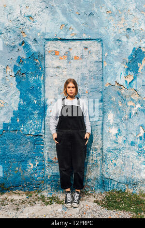 Portrait of woman, weathered wall in background Stock Photo
