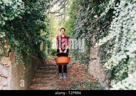 Woman with basket descending ivy-covered stairs Stock Photo