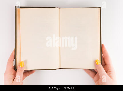 A woman (female) two hands hold an empty (blank) book spread isolated on white background, flat lay Stock Photo