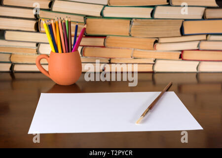 Paper and pencils on the wooden table, books background Stock Photo