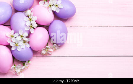 Easter eggs and  white flowers (Cherry blossom ) on pink wooden table. Stock Photo