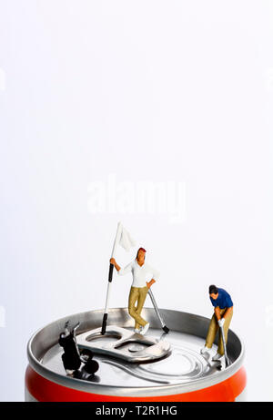 Conceptual diorama image of miniature figures playing golf on the top of a drinks can