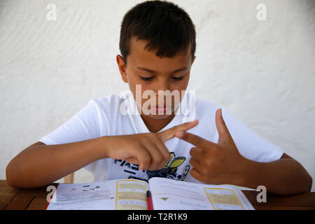11-year-old boy doing homework in Salento, Italy Stock Photo